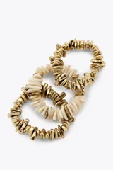 Pack de tres pulseras elásticas con piezas de diferentes formas, tamaños y colores en dorado y blanco.