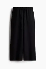 Pantalón negro de corte recto y relajado, con cintura elástica ajustable con cordón y bolsillos laterales.