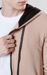 Campera beige con cierre frontal, capucha con cordón ajustable, bolsillos laterales con cierre y calce regular.
