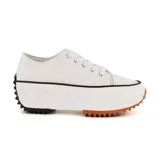 Zapatillas deportivas urbanas negras con puntera blanca y suela gruesa con detalles marrones.