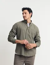 Camisa color ladrillo de lino y algodón, con cuello abotonado, manga 3/4 con puños arremangados, corte clásico y bolsillo de parche en el pecho.