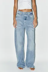 Pantalón de jean celeste de corte extra wide leg, tiro alto, cinco bolsillos, trabillas en la cintura y cierre con cremallera y botón metálico.