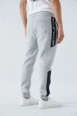 Pantalón de jogging gris oscuro de felpa con puños, cintura ajustable con cordón y logo estampado en la pierna.