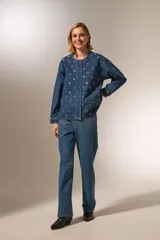 Campera de jean azul con manga larga, corte holgado, cuello redondo y cierre frontal con botones. Presenta bolsillos delanteros y detalles de ojales metálicos.