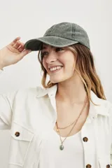 Gorra verde oliva de algodón lavado, estilo béisbol, con visera curva y correa ajustable en la parte trasera.