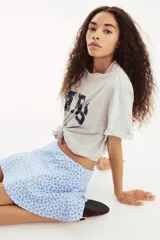 Short pollera mini de tejido suave con efecto neopreno, color celeste con estampado floral en azul oscuro. Modelo ajustado con elástico oculto en la cintura y nesgas que aportan volumen.