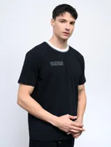 Remera color arena de corte clásico con cuello redondo ribeteado en blanco y logo Umbro estampado en el pecho.