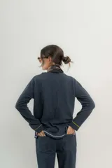 Sweater de punto gris con cuello en V y ribetes en contraste.