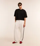 Pantalón wide leg de helanca color blanco, con cintura elástica ajustable con cordón, bolsillos laterales, raya lateral negra y bajo ajustable.