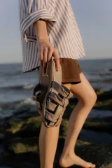 Sandalias tipo mule de cuero color marrón chocolate, con diseño de tiras anchas cruzadas y suela plana.