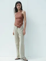 Top halter color ladrillo con textura y detalle de encaje a tono en cuello, sisas y ruedo.