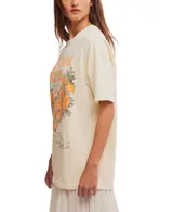 Remera color crema con estampado de flores de amapola color naranja y texto en la parte delantera.