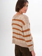 Sweater de punto con rayas horizontales en color gris y negro. Tiene cuello redondo y mangas largas con puños ajustados. El corte es holgado y llega hasta la cintura.