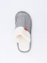 Pantuflas cerradas color rosado, con interior de felpa blanca y detalle de moño rojo.