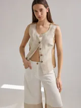 Chaleco color beige de lino con corte entallado y cierre frontal con botones de madera.