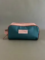 Necessaire rectangular de lona verde con detalles en cuero color suela y etiqueta con logo de la marca Sierra Mora.