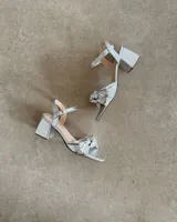 Sandalias plateadas de cuero vacuno con taco bloque de 6 cm y tira delantera con detalle de nudo.