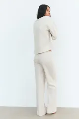Sweater color crema de tejido suave, con cuello redondo en rib y mangas largas sin costuras.