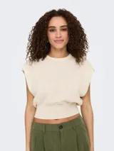 Top tejido color crema sin mangas con cuello redondo y corte regular.