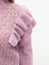 Sweater lila de tejido calado con cuello alto y mangas largas abullonadas con volados.