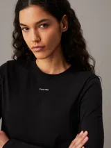 Remera negra de manga larga Calvin Klein, corte slim, cuello redondo y logo pequeño debajo del cuello.