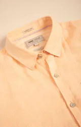 Camisa de manga larga color durazno, confeccionada en lino orgánico, con cuello italiano, cierre con botones y bolsillo en el pecho con logo bordado al tono.