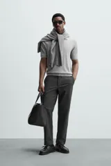 Pantalón chino de vestir negro, corte slim fit, con bolsillos laterales y traseros. Cierre frontal con cremallera y botón.