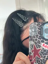 Par de broches para el pelo negros con lunares blancos.