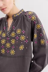 Camisa gris de algodón con bordados florales dorados y fucsias, lentejuelas y detalles de puntilla en mangas.