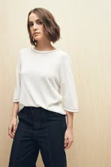 Top blanco de tejido liviano con cuello a la base y mangas 3/4.