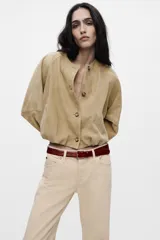 Pantalón de tiro alto color beige, con bolsillos laterales y corte ancho.