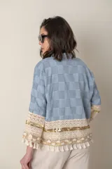 Chaqueta celeste con diseño a cuadros, sin forro, con apliques bordados en mangas y ruedo.