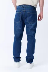 Pantalón de jean azul oscuro, corte slim fit, tiro medio y bolsillos delanteros y traseros.