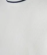 Sweater de manga larga color blanco hueso con textura acanalada vertical y cuello redondo con ribete negro contrastante.