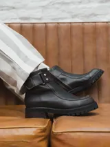 Bota corta de cuero color marrón oscuro con hebilla lateral y suela track.