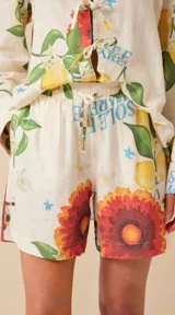 Short tipo bermuda de lino color crudo con estampado de limones, flores y girasoles. Tiene cintura elastizada con lazo ajustable y bolsillos laterales.