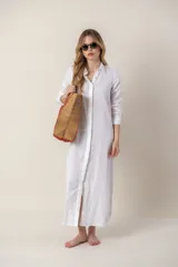 Camisola larga de lino color blanco, con cuello camisero y cierre frontal con botones.