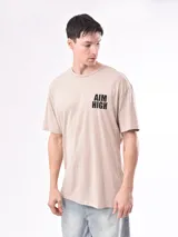 Remera beige de corte recto con estampado 'Aim High' en el pecho.