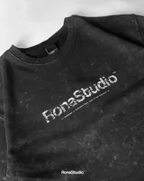 Conjunto deportivo negro con efecto lavado a la piedra, compuesto por una remera de manga corta con logo estampado en el pecho y un short con cordón ajustable en la cintura.