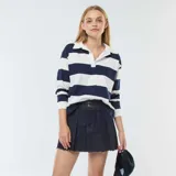 Falda pantalón corta de denim azul oscuro con tablas y ruedo desflecado.