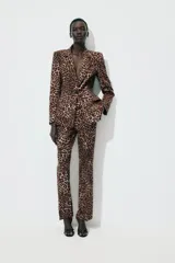 Pantalón largo de tiro alto con estampado animal print de leopardo en tonos marrones. Tiene bolsillos laterales y cierre frontal con cremallera, botón interior y gancho metálico.