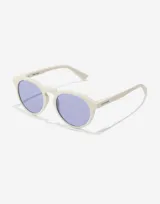 Lentes de sol Hawkers unisex, modelo Warwick Raw, con montura color marfil y lentes celestes.