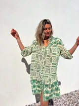 Vestido camisero largo color crudo con estampado geométrico en verde, de corte holgado y manga 3/4.