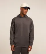 Buzo deportivo gris con capucha ajustable, manga larga ajustada, bolsillo canguro, detalles en recortes y textura.