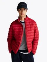 Campera acolchada roja de Tommy Hilfiger, con cuello alto y cierre de cremallera. Cuenta con dos bolsillos laterales con cremallera y logo bordado en el pecho.