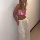 Top corto rosado con lentejuelas, breteles finos y espalda descubierta con ajuste de cadena.