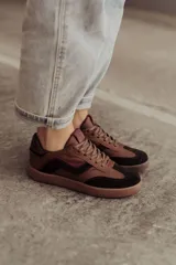 Zapatillas bajas de cuero color marrón con suela de goma color caramelo y cordones marrones.