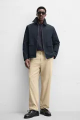Pantalón color arena de corte recto, confeccionado en tejido de algodón con estructura canvas. Cuenta con cintura ajustable con trabillas laterales, bolsillos frontales y traseros de vivo. Cierre frontal con cremallera y botón.