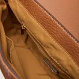 Bandolera pequeña de material símil cuero color habano, con solapa frontal y cierre superior. Presenta un logo metálico XL en el frente y herrajes dorados. Incluye correa larga regulable y desmontable.