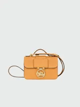 Bandolera Longchamp modelo Box-Trot XS, color amarillo, con correa fina ajustable y logo circular en el frente.